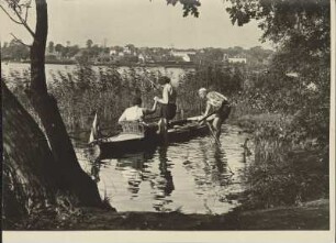 Mark Brandenburg. Bootspartie am Flakensee. Eine Frau steigt ins Ruderboot, das von einem Mann festgehalten wird. Im Bildhintergrund die Stadt Erkner