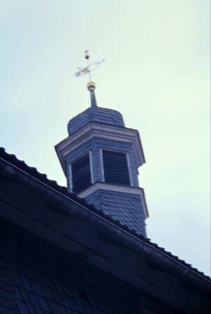 Dachreiter der Kirche mit goldenen Turmknopf und der Wetterfahne