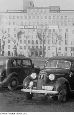 Zwei parkende Autos vor dem Ringmessehaus (BMW 321 oder BMW 326) vor dem Ring-messehaus