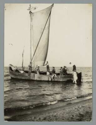 Wir fahren heute mit dem Fischer von Nidden : Nidden (Nida/Litauen). Segelfischkutter (Nid 27) im Küstengewässer mit Urlaubern. Blick vom Strand aus