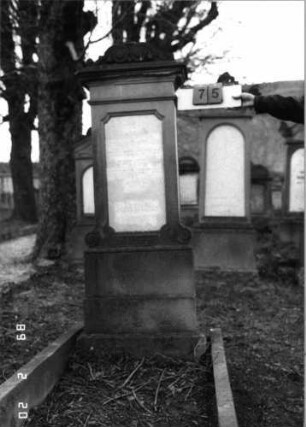 Grabstein 75 (Index: 99798569) Material: Sandstein, Schriftplatte Marmor Zustand: gut Maße HxBxT: 178x47x25 cm Beschreibung: Stele mit Volutenaufsatz, Schriftplatte, Sockel: Grabstein 75