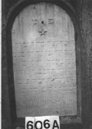 Grabstein 606 (Index: 99900687) Material: Sandstein, Marmor Zustand: Sandstein angewittert, Marmor gut erhalten Maße HxBxT: 200x60x24 cm Beschreibung: aufgesockelte Stele mit Giebelaufsatz, Giebel- und Eckakroterien, im Bogenfeld der Schrifttafeld Stern Symbolik: Stern: Grabstein 606A