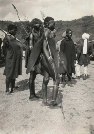 Ostafrika. Afrikaner (in Stammestracht ?) und zwei Inder mit Turban (Sikh ? )