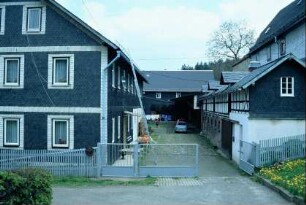 Blick in einen Dreiseithof; links Wohnhaus, rechts Stall