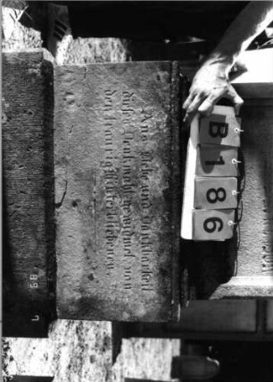 Grabstein 186 (Index: 99797620) Material: Sandstein, weiß Zustand: leicht verwittert Maße HxBxT: 200x67x20 cm Beschreibung: Stele, Giebel rechteckig erhöht, getreppter Sockel Symbolik: Blüte, Rundbogenfries: Grabstein 186B