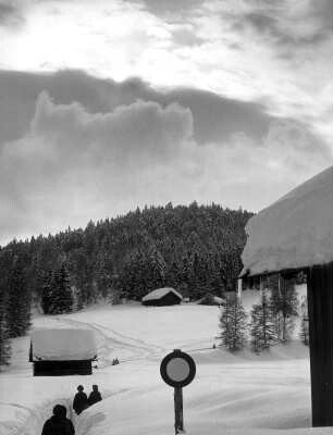 Österreich. Seefeld/Tirol. Das eingeschneite Verkehrsschild und das Dach zeigen die beträchtliche Schneehöhe. Wunderbare Bedingungen für Wintersport oder auch für Winterwanderungen - die hier fotogafierten Urlauber tun es.