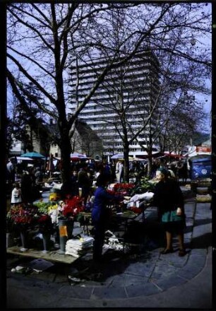 Lörrach: Marktszene, Vordergrund Blumenstand, Hintergrund Hochhaus