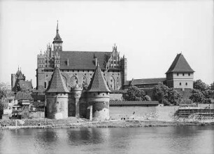Marienburg (Malbork/Polen). Ordenschloss, Hochschloss. Gesamtansicht von Nordwesten über die Nogat. Vorn Brücktor, rechts Herrendansker