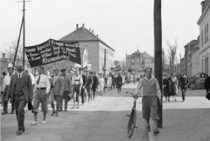 Demonstrantinnen und Demonstraten mit dem Transparent: "Frauen heraus, Frauen erwacht, in Euren Händen liegt die Macht, in Eurem Willen liegt der Sieg, Klassenkrieg!" in Heidenau, in der Nähe der Löwen Drogerie Thürmer