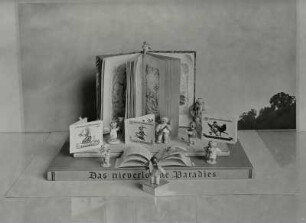 Fotomärchenbuch. Illustration zum Märchen-Gedicht von Else Seifert "Besuch der Buchwoche". Arrangement mit dem Buch "Das nie verlorene Paradies", Holzengeln (Wendt und Kühn) und Märchenbüchern