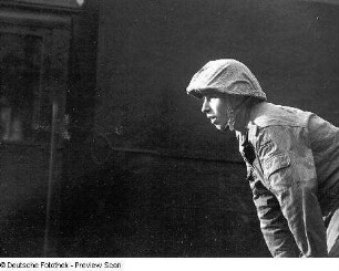 Deutschland . Truppenübungsplatz Klietz. Nationale Volksarmee - Landstreitkräfte. Soldat in Felddienstuniform mit Stahlhelm vermutlich als Einweiser in beobachtender Haltung