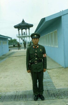 Eiserner Vorhang in Panmundschom : Ein nordkoreanischer Soldat steht auf der Grenzlinie. Im Rücken hat er US Soldaten und deren Beobachtungsturm. Aufgenommen in Panmundschom im Juli 1981