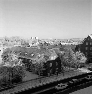 Mewesstraße: Blick vom Kreishaus auf Wohnblocks mit Grünanlagen: rechts Pkws: dahinter Abzweigung der Reimer-Hansen-Straße: hinten Hochhäuser am Poggenbreeden: Winter