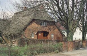 Bünningstedt: Bauernhaus mit Reetdach: straßenseitige Giebelfront Wirtschaftstrakt mit Scheunentor
