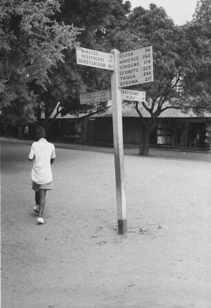 Wegweiser : Ein Mann neben einem Wegweiser in Morogoro.