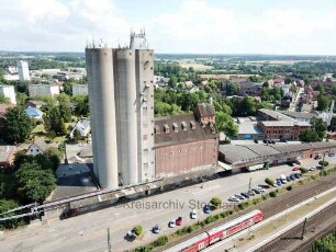 Bad Oldesloe: Luftbild Richtung Süden vom Bahnhofsgelände, mittig Getreidesilo der Firma Johannes Ströh, unten Regionalbahn