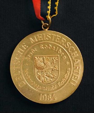Goldmedaille Deutsche Meisterschaften in Kurzschrift und Maschinenschreiben in Rodalben 1984 am schwarz-rot-goldenen Band : Sammlung Deutscher Stenografenbund. Goldmedaille Deutsche Meisterschaften in Kurzschrift und Maschinenschreiben in Rodalben 1984 am schwarz-rot-goldenen Band. Messing; Durchmesser 50 mm, Gewicht 47,5 g (1984; Deschler & Sohn, München). Dresden: SLUB R c 0536