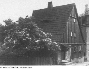 Bautzen, Vor der Fischerpforte 6. Sogenanntes Hexenhäuschen (vor 1604). Straßenansicht mit blühendem Holunderbusch