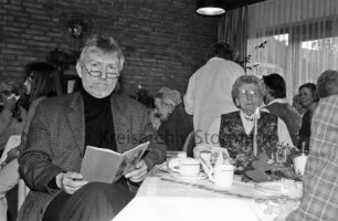 Ahrensburg: Reeshoop: Weihnachtsfeier: Landrat Klaus Plöger beim Vorlesen einer Weihnachtsgeschichte: Bewohner Erna Möller und Mitbewohnerinnen an Kaffeetischen, hinten Pflegerin: 22. Dezember 1998