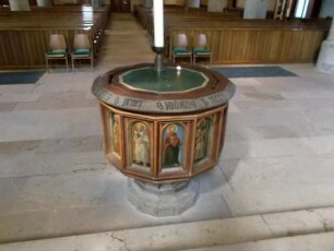Stadtkirche-Langhaus Innen - Spätgotischer Taufstein unter dem Triumphbogen mit Umschrift sowie farbiger Darstellung der Heiligen in Ansicht von Osten