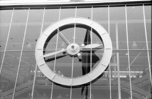 Basel: große Uhr in der Glaswand der Ausstellungshalle