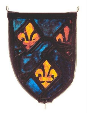 Farbglasscheibe in Schildform mit heraldischen Lilien. Zugehörig zu einer Gruppe von vier Scheiben (vgl. Gm.009, 146, 147)