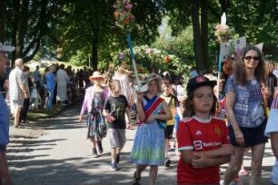 Bad Oldesloe: Kindervogelschießen: Einlauf des Festumzuges auf den Festplatz (Exer) über Konrad-Adenauer-Ring, im Vordergrund Schulklassen der Klaus-Groth-Schule mit Blumenschmuck und Blumenbögen, 30.06.2022