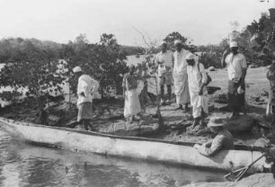 Im Einbaum : Expeditionsmitglieder in und an einem Einbaum der zu Wasser gelassen wurde