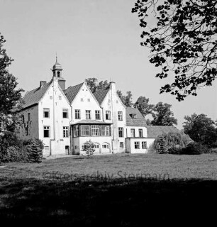Kloster Nütschau: Herrenhaus: Südfront mit Wintergarten: vorn Rasenfläche: rechts und links Bäume