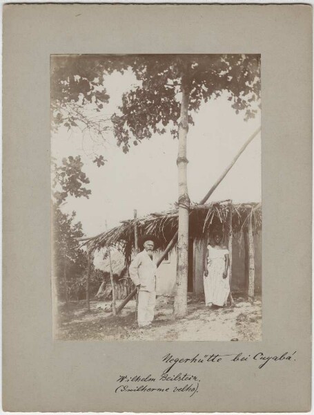 Wilhelm Beilstein in front of a hut in Cuiaba, together with its inhabitant