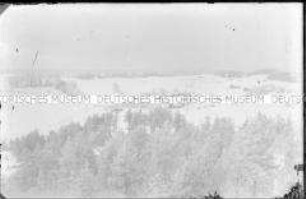 Weiter Blick über eine Winterlandschaft mit einer kleinen Ansammlung von Häusern