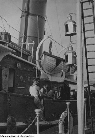 Unbekanntes Schiff in einem Hafen. Matrosen an der Reling