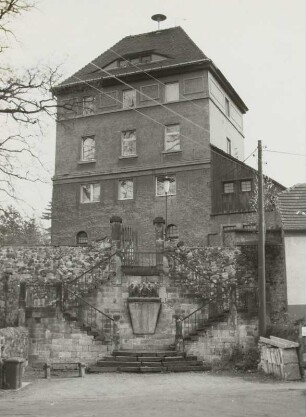 Dresden-Cossebaude, Talstraße 7 a. Steinernes Haus (ehem. Kapelle, Baubeginn 13. Jh., E. 19. Jh.). Straßenansicht mit Treppenaufgang und Denkmal für die Gefallenen des 1. Weltkrieges (nach 1918)