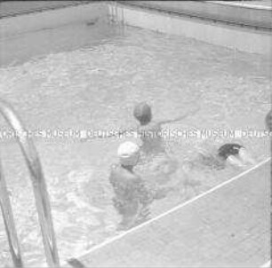 Drei Passagiere im Schwimmbad des Hochseepassagierdampfers "Columbus"