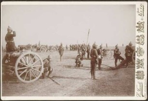 Soldaten mit filzbezogenen Pickelhauben, an Kanonen stehend.