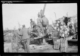 Zwischen Comines (=Comines-Warneton, Belgien) und Messines (=Mesen, Belgien): Soldaten an einer "Feuerstellung der Flakbatterie Bragard (Flak auf Kraftwagen [mit Tarnfarbe])", daneben Flak-Munition (Seitansicht)