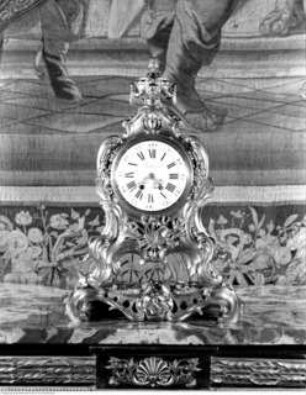 Uhr mit Dekor aus Musikinstrumenten und bekrönender Urne
