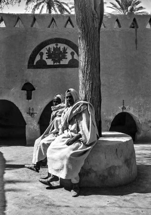 Männer auf dem Markt : Zwei Männer sitzen um einem Baum auf dem alten Sklavenmarkt der Oase Ghadames.