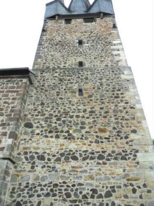 Evangelische Kirche - Kirchturm (frühgotisch 13 Jhd) von Norden mit Schießscharten in den Mittelgeschossen sowie Werksteinen im Mauersteinverband