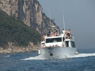 Insel Capri - Boot vor der Küste : Ein Boot fährt mit Touristen zur Blauen Grotte. Aufgenommen auf der italienischen Mittelmeerinsel Capri am 22. Juli 2004