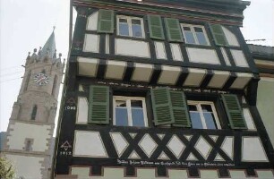 Ladenburg: Altes Fachwerkhaus mit Kirchturm von unten