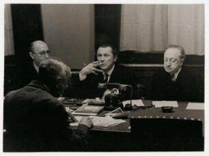 Sitzung der Sektion für Dichtkunst der Akademie der Künste in Berlin. Die Aufnahme zeigt den Vorstand mit dem Präsidenten der Akademie der Künste Walter von Molo. von links: Oskar Loerke, Walter von Molo, Ludwig Fulda; mit dem Rücken zum Betrachter sitzend: Bernhard Kellermann