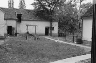 Innenhof : Blick über einen begrünten Innenhof, der von Stallungen umgeben ist