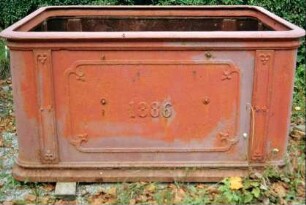 alter Brunnentrog aus Eisen an einer Dorfstraße; Jahreszahl 1886; beschädigt