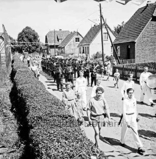 Grönwohld: Amtsfeuerwehrfest des Amtes Lütjensee: Festumzug: vorn rechts Spielmannszug: dahinter Feuerwehrkapelle: links Hecke: rechts hinten Wohnhäuser mit Vorgärten