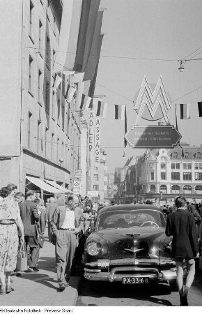 Blick entlang des belebten Neumarktes, Passanten betrachten einen PKW