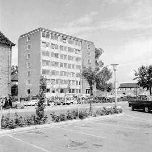 Erweiterungsbau "Hochhaus" [später Gebäude B]: III. Bauabschnitt: Gebäude nach Fertigstellung mit Filiale der Kreissparkasse Stormarn: davor Parkplatz mit Pkws: links Ecke des Finanzamtes und Einmündung Bangertstraße: rechts Pkw: hinten Erweiterungsbau II. Bauabschnitt: im Vordergrund Mommsenstraße und Parkplatz am Bahnhof