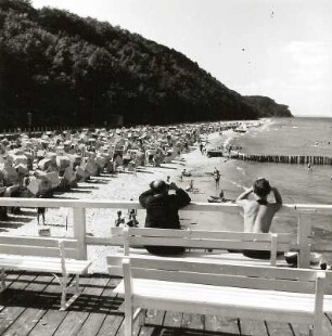 Sellin. Strand mit Badegästen und Strandkörben. Blick von der Seebrücke gegen die Steilküste
