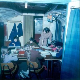 Zirkus Krone. Blick in den Schulwagen mit Lehrerin und Schülern