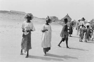 Reisefotos Senegal. Einheimische am Strand. Im Hintergrund Hütten des Dorfes